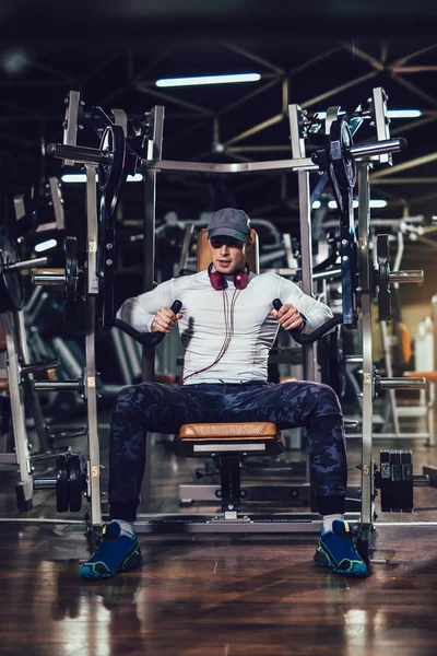 Joven hombre guapo en ropa deportiva haciendo ejercicio en el gimnasio — Foto de Stock