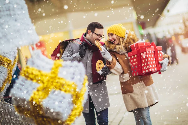 Νεαρό ζευγάρι ντυμένος σε χειμωνιάτικα ρούχα κρατώντας κουτιά δώρων — Φωτογραφία Αρχείου