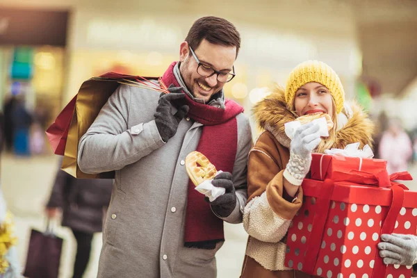 Jong stel gekleed in winter kleding houden geschenkdozen elkaar overtreffen — Stockfoto