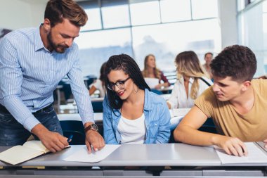 Genç öğrenciler üniversite lisi konusunda sınıfta profesör dinliyor