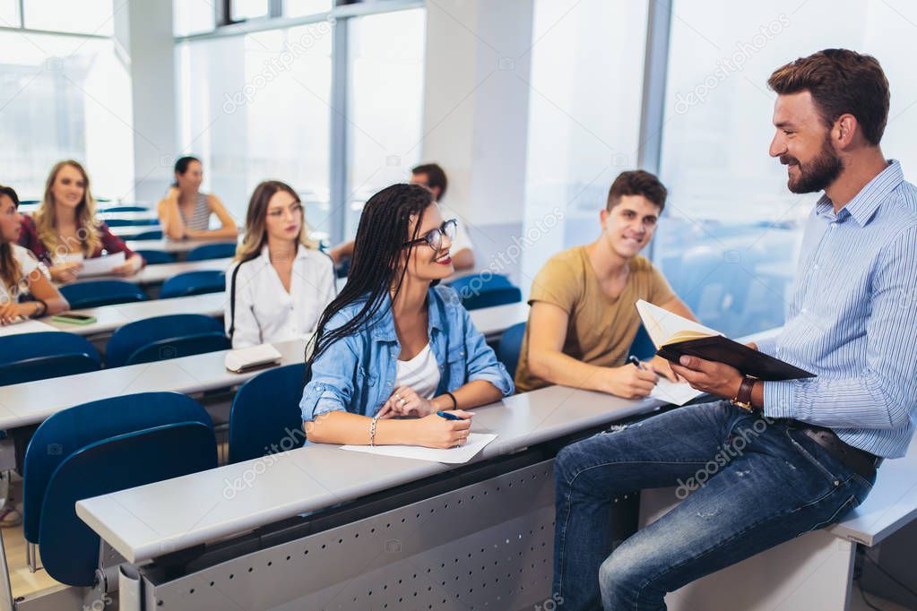 Young students listening to professor in the classroom on colleg