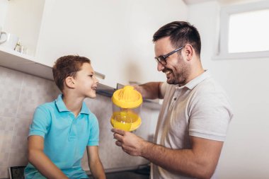 Mutlu baba ve çocuk mutfakta kucaklaşmak için duruyor. Onlar tutun