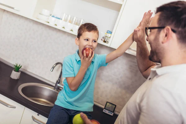 Feliz padre e hijo de pie en la cocina en abrazo. Se sostienen —  Fotos de Stock