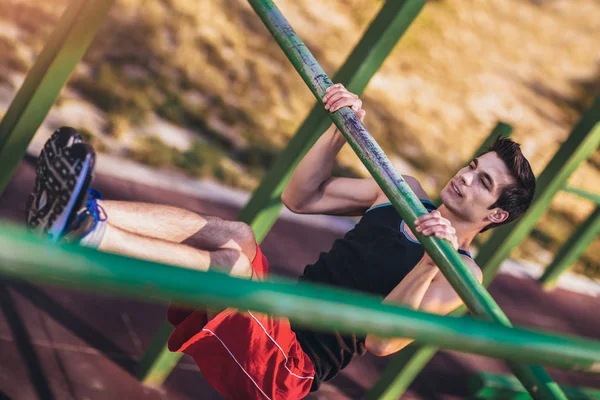 Homem de fitness fazendo exercícios na barra horizontal ao ar livre — Fotografia de Stock