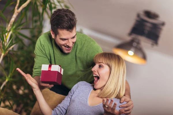 Счастливая женщина получает подарок от своего парня во время сидения — стоковое фото