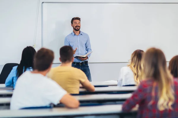 Jonge studenten luisteren naar professor in de klas op colleg — Stockfoto