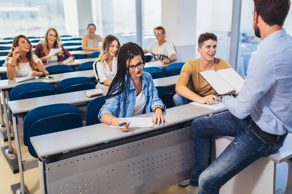 Mladí studenti poslouchají profesora ve třídě na kolektivu — Stock fotografie