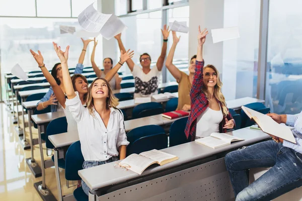 Skupina studentů zvyšování rukou ve třídě na přednášku — Stock fotografie