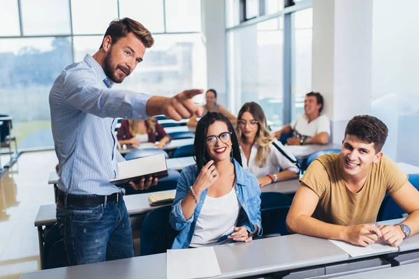 Genç öğrenciler üniversite lisi konusunda sınıfta profesör dinliyor