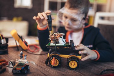Mutlu gülen çocuk teknik oyuncaklar yapıyor. Sekmedeki teknik oyuncak