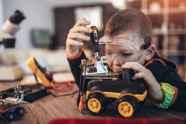 Mutlu gülen çocuk teknik oyuncaklar yapıyor. Sekmedeki teknik oyuncak