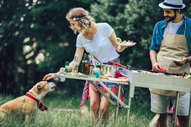 Mutlu arkadaşlar et pişiriyor barbekü partisinin tadını çıkarıyor.