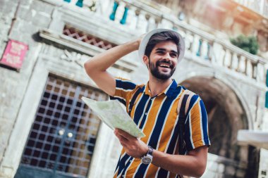 Sırt çantalı yakışıklı sakallı turist C boyunca seyahat ediyor.