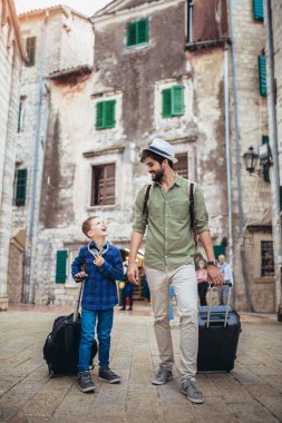 Yakışıklı bir adam ve küçük oğlu tatile çıkıyorlar.