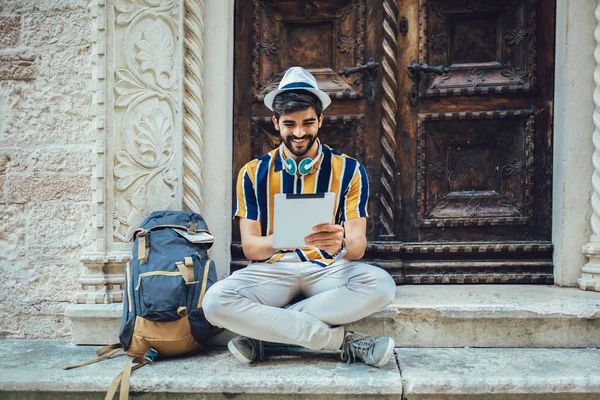 Jonge knappe toeristen die digitale tablet gebruiken in een stad. — Stockfoto