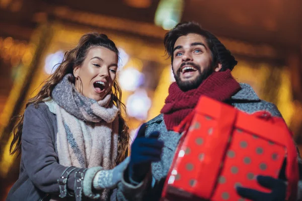 Pareja joven en el centro de la ciudad con luces de vacaciones en backgr —  Fotos de Stock