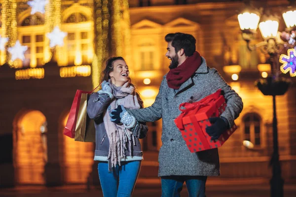 Jong stel in het centrum met vakantie brights in backgr — Stockfoto