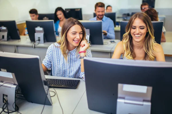 Estudiantes universitarios sentados en un aula, usando computadoras durante — Foto de Stock