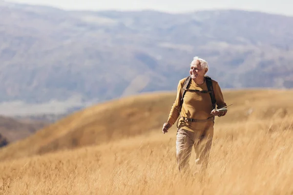 Senior man on hike through beautiful countryside in autumn. — Stock Photo, Image