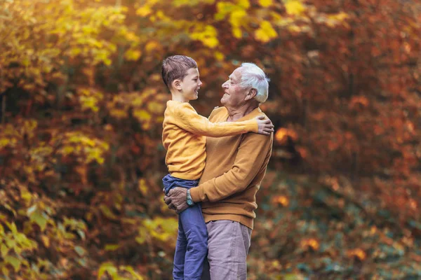 Nagyapa és unokája együtt az őszi park — Stock Fotó