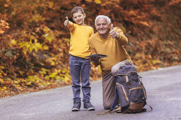 Senior mit Enkel bei Waldspaziergang und zeigt Daumen hoch. — Stockfoto