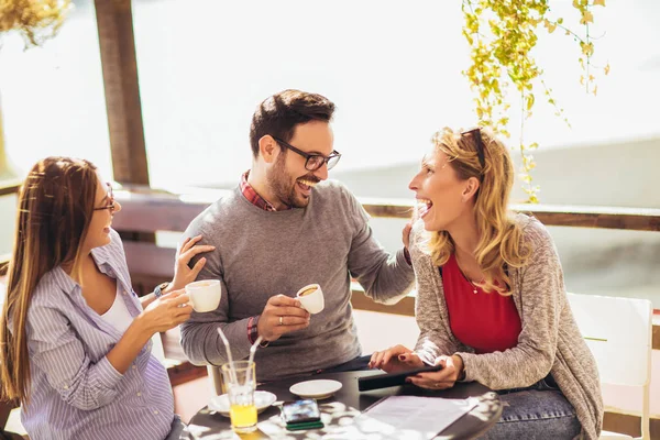 Cheerful group of friends having fun in cafe, using digital tabl — 스톡 사진