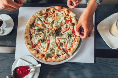 Pizza dilimi tutan insan elinin yakın çekim