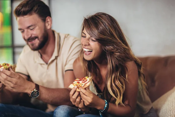 Casal comendo pizza no café moderno. Eles estão rindo e comendo — Fotografia de Stock