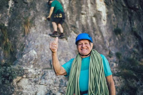 Idősebb ember kötéllel, aki felkészül a sziklamászásra.. — Stock Fotó