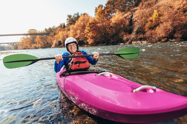 Un uomo anziano attivo che remava in kayak. Uomo capelli grigi godere di fiume kaya — Foto Stock