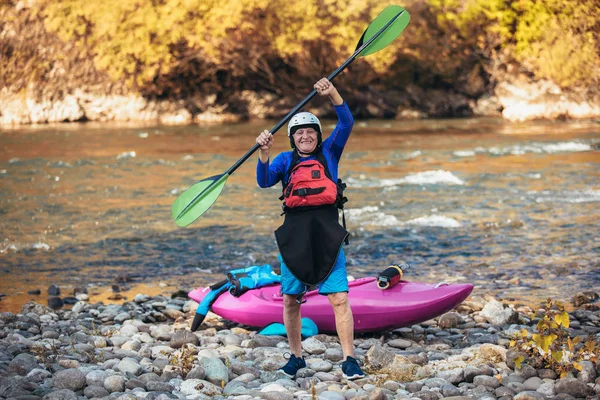 Hombre mayor preparándose para la excursión en kayak en un río de montaña. — Foto de Stock