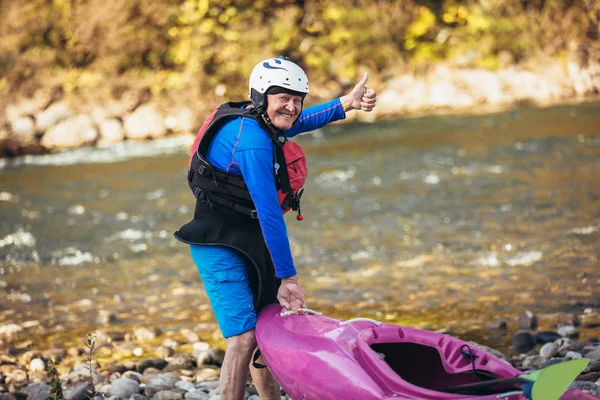 Hombre mayor preparándose para la excursión en kayak en un río de montaña. — Foto de Stock