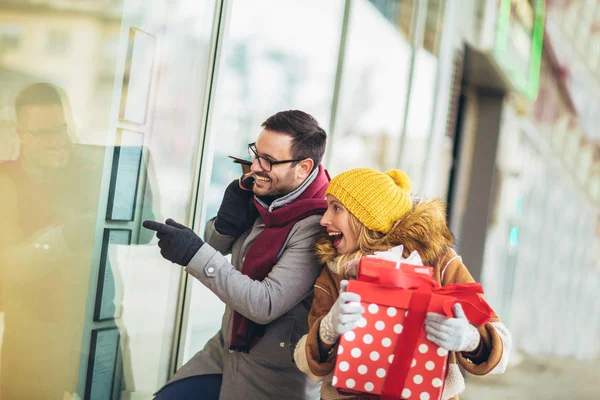 Janela de casal jovem compras em um dia de inverno, à procura de um Chri — Fotografia de Stock