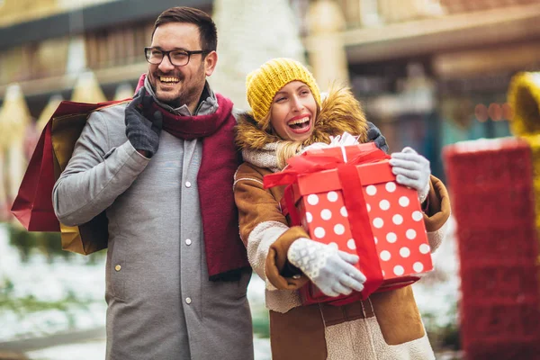 Pareja joven vestida con ropa de invierno sosteniendo cajas de regalo outdo —  Fotos de Stock