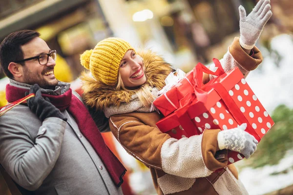 Jong stel gekleed in winter kleding houden geschenkdozen elkaar overtreffen — Stockfoto