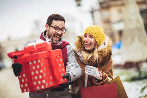 Jong stel gekleed in winter kleding houden geschenkdozen elkaar overtreffen — Stockfoto