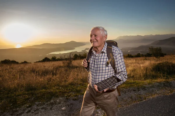 Gelukkige oude man bereikt net de top van de heuvel. Knappe oudere man h — Stockfoto