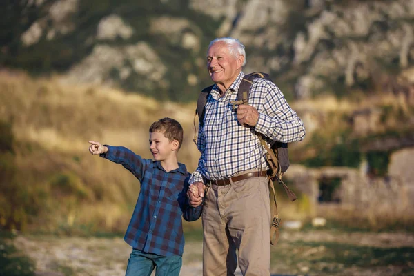 Grandfather and grandson holding hands while hiking Royalty Free Stock Photos