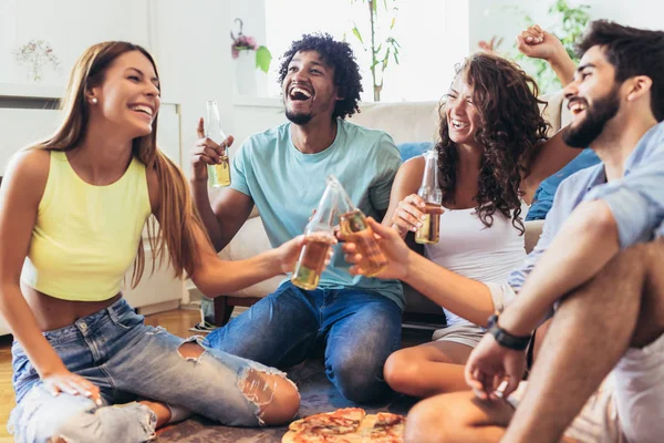 Grupo de jóvenes amigos multiétnicos comiendo pizza en casa y hav — Foto de Stock