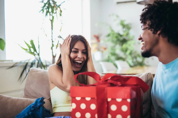 Mężczyzna daje prezent niespodzianka dla kobiety w domu. — Zdjęcie stockowe