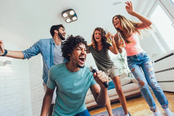 Group of friends playing karaoke at home.Group of friends having