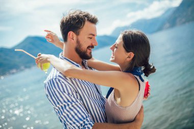 Genç çift arkadaşı ile plajda meyve yeme- yaz partisi