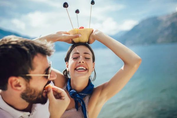 Молода пара їсть фрукти на пляжі-літній вечірці з другом — стокове фото