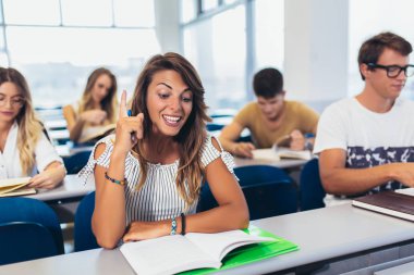 Uluslararası öğrenciler denoluşan bir grup dershanede yazı pişme ve konuşma