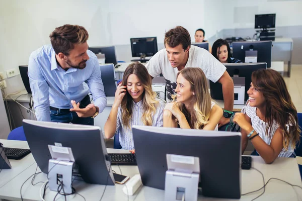 Estudantes universitários sentados em uma sala de aula, usando computadores durante — Fotografia de Stock