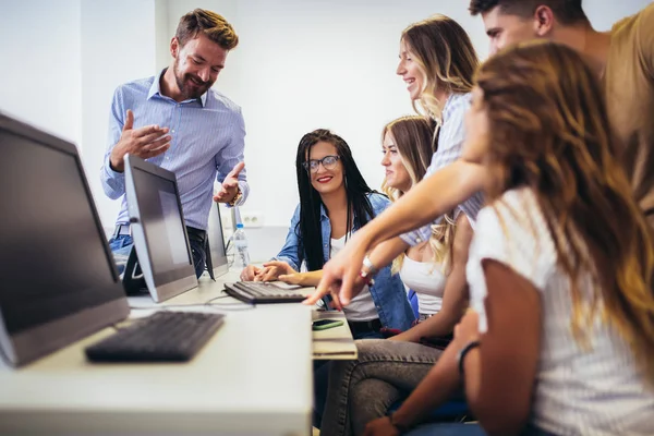 Högskolestudenter som sitter i ett klassrum och använder datorer — Stockfoto