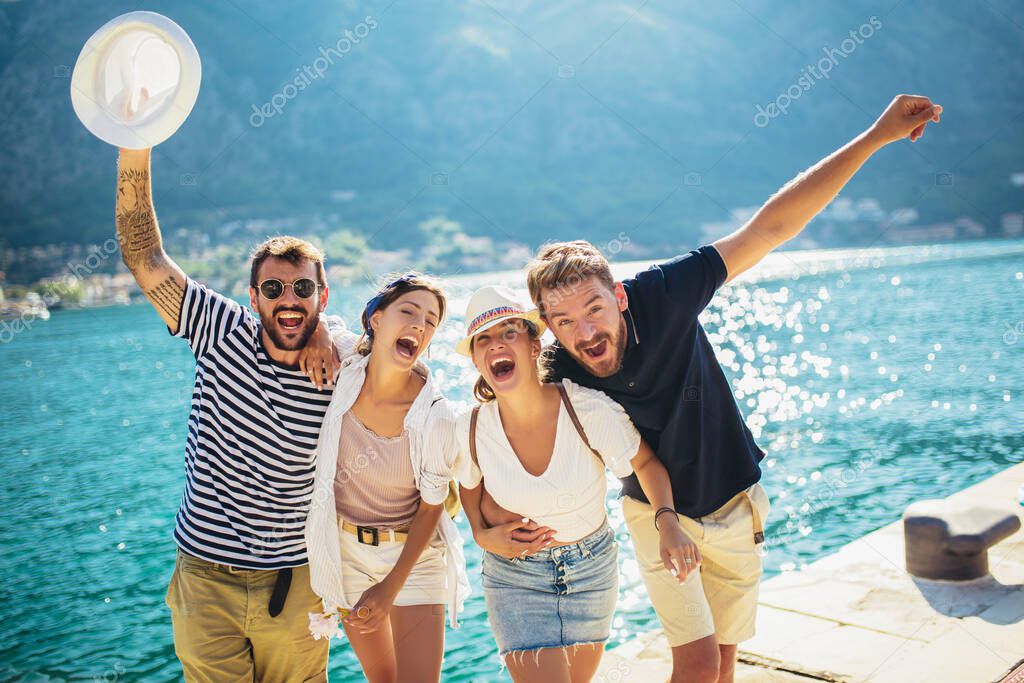 Group of friends having fun near the sea on vacation