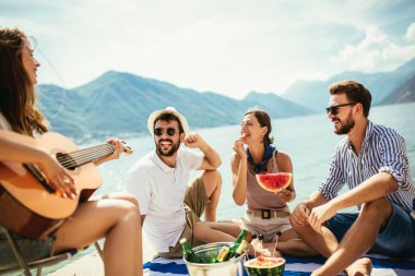 Gitarlı bir grup arkadaş sahilde eğleniyor..