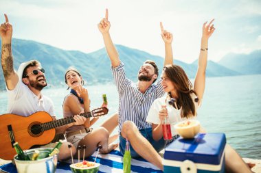 Gitarlı bir grup arkadaş sahilde eğleniyor..