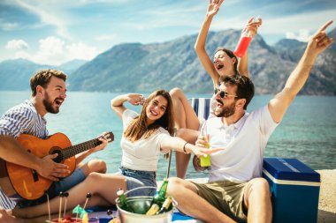 Gitarlı bir grup arkadaş sahilde eğleniyor..